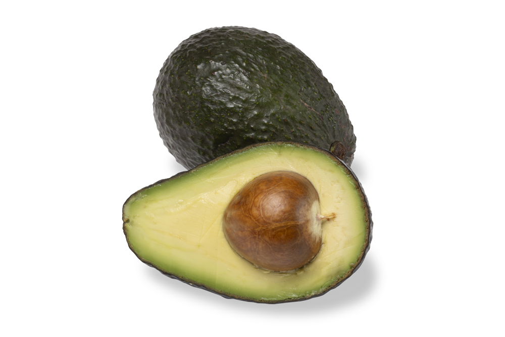Whole and halved ripe avocado with pit